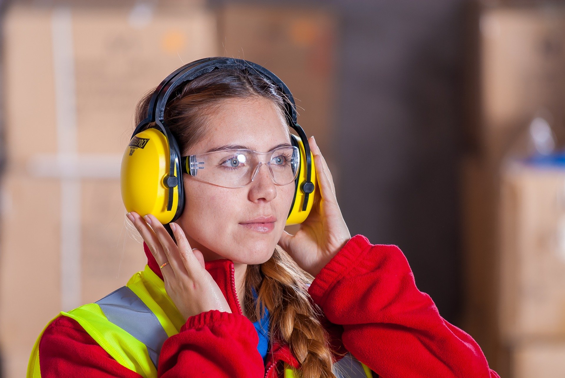 Trabajadora de la industria usando EPI auditiva
