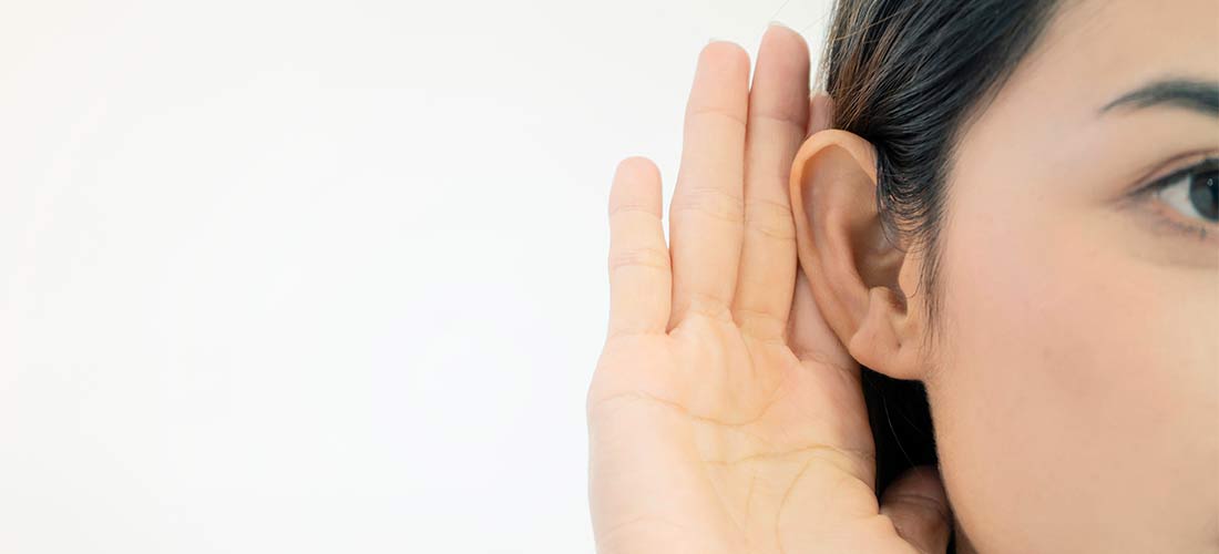 Mujer oyendo con un audífono